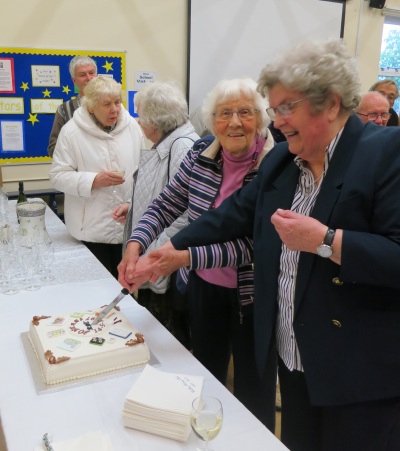 Barbara Wootton, on the left in the pink jumper, and Rita Ford cut the cake